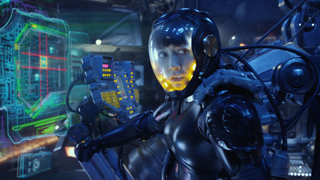Person in black sci-fi armor and a glass helmet looking at a glowing green holographic display.