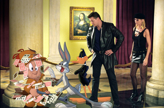 Animated Bugs Bunny and Daffy Duck stand before a man and woman in a room with a Mona Lisa painting.