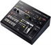 A black digital audio mixer featuring multiple control knobs, buttons, and faders on its top surface.