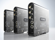 Three silver Roland electronic devices with various input and output ports arranged diagonally.