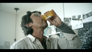 A man tilts his head back to swallow contents from an orange prescription pill bottle.