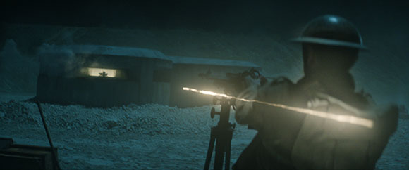 A soldier in a helmet fires a machine gun toward a building in the dark.