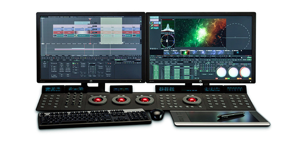 Dual monitors displaying video editing software above a large control surface, keyboard, and graphics tablet.