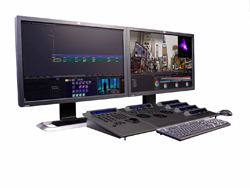 Two computer monitors displaying video editing software next to a specialized control surface and keyboard.
