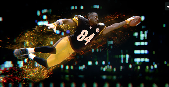 Football player in a black jersey with number 84 diving through a splash of liquid light to catch a ball.