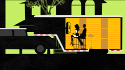 Silhouettes of a man and woman sitting inside a brightly lit trailer at night.