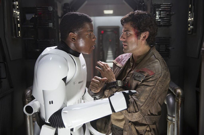 A man in white armor and a man in a brown jacket face each other closely in a metallic hallway.