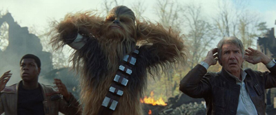 A tall hairy creature, a man in a brown jacket, and a younger man look on with surprised expressions.