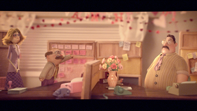 Three claymation characters in an office with desks, pink decorations, and a bouquet of flowers.