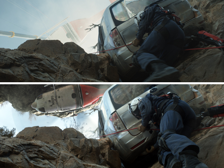 A rescuer in dark gear climbs a steep, rocky slope near a silver car perched on a ledge.