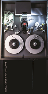 Top-down view of a professional film scanner with two large silver reels and various mechanical components.