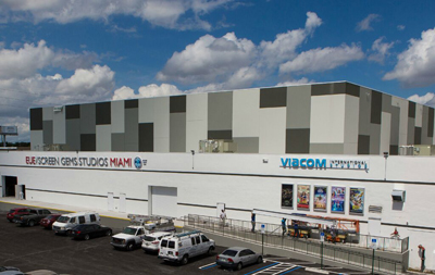 A large, modern white and grey studio building with Viacom and EUE/Screen Gems signage under a cloudy sky.