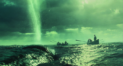 Two small rowing boats on a dark, choppy ocean under a green sky with a vertical beam of light.