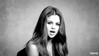 Black and white portrait of a woman with long hair looking forward with her mouth slightly open.