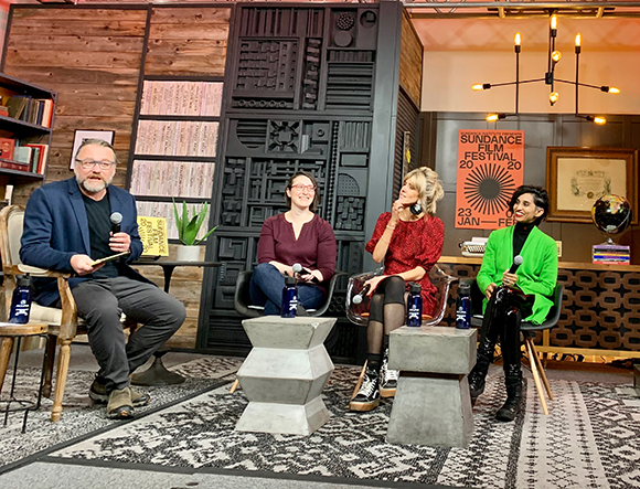 Four panelists sit in chairs on a stage with a Sundance Film Festival poster in the background.