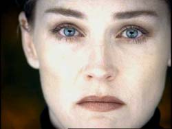Close-up portrait of a person with light skin and striking blue eyes looking directly at the camera.