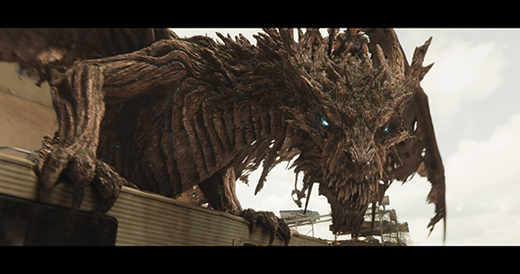A massive creature with skin made of textured brown wood and glowing blue eyes perched on a building.