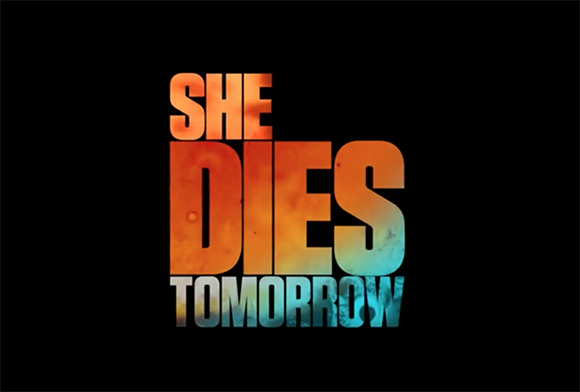 Title logo for She Dies Tomorrow in large, orange and blue textured block letters on a black background.