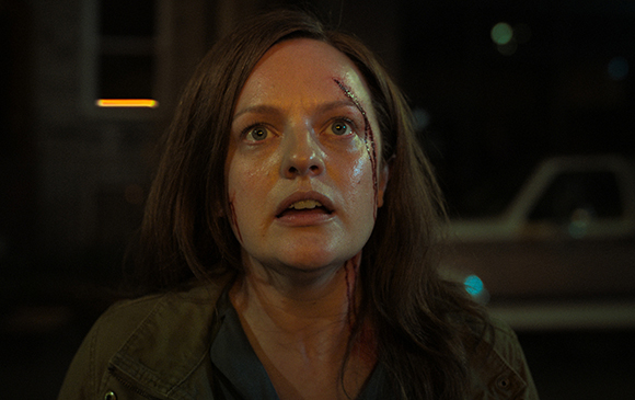 A woman with bloodied scratches on her face looks upward with a startled expression at night.