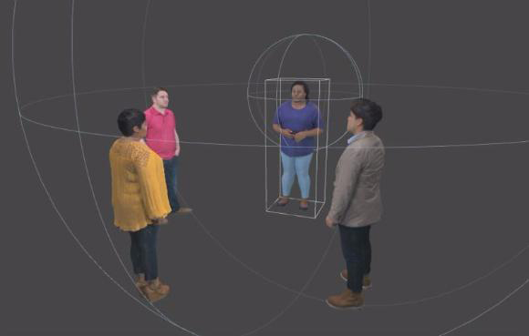 Three people stand in a circle around a person enclosed in a rectangular wireframe within a large sphere.