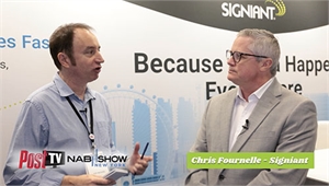 Two men in professional attire talking in front of a Signiant branded backdrop.