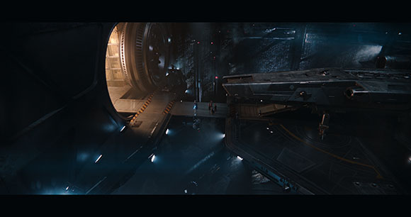 A dark, cavernous sci-fi hangar with a large circular vault door and a large spacecraft docked on a platform.