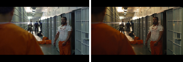 A man in a blood-stained white shirt and orange pants stands in a prison corridor with bars on both sides.