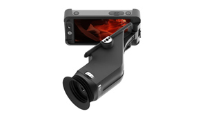 A smartphone mounted to a black handheld lens attachment with a large front lens.