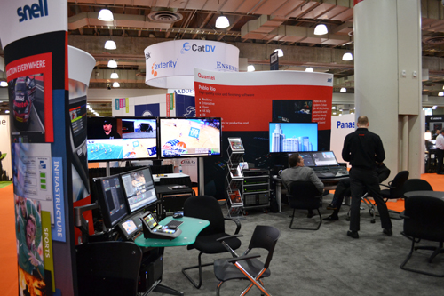 Trade show exhibition booths with digital displays, monitors, and company signage.