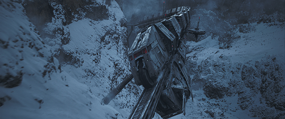 A heavy industrial train moving along a track through a steep, snow-covered mountain landscape.