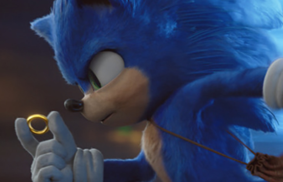 Blue anthropomorphic hedgehog looking intently at a small gold ring held between two fingers.