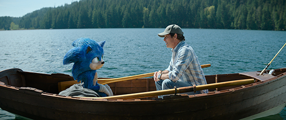 A blue anthropomorphic hedgehog sits in a wooden rowboat facing a man on a calm lake.