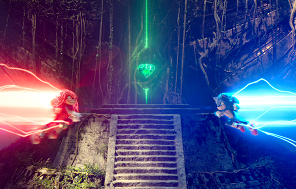 Knuckles and Sonic dash toward a glowing green gem in a dark, vine-covered stone temple.