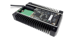 An open electronic device showing a circuit board mounted on a black finned heat sink.