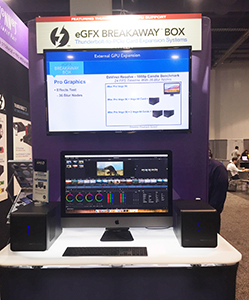 A display booth shows an eGFX Breakaway Box sign, a large monitor with graphics, and a desktop computer setup.