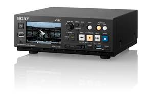 A black Sony 4K media player with a digital display and various control buttons and ports.