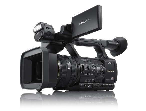 A black Sony NXCAM professional video camera with a large lens and an upward-facing LCD monitor.