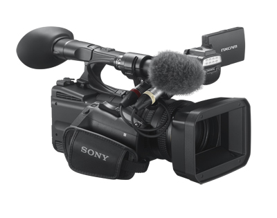 A black Sony professional video camera equipped with a shotgun microphone and a large lens hood.