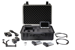 An open black protective equipment case with a small monitor, power adapter, cables, and batteries.