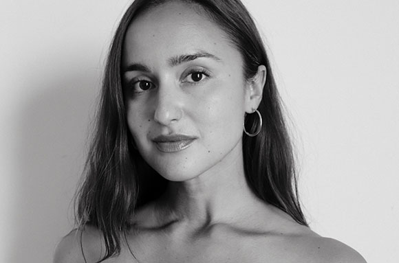 Black and white close-up portrait of a woman with long hair and hoop earrings.