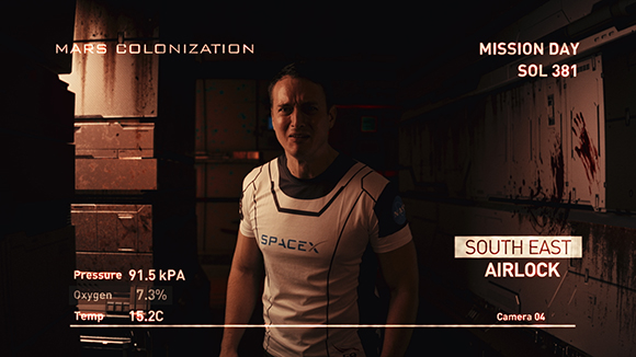 A man in a white SpaceX shirt stands in a dark, industrial Mars colonization corridor.