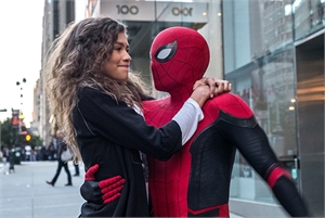 A woman with long curly hair embraces a person in a red and black Spider-Man suit on a city sidewalk.