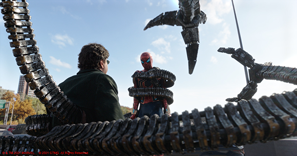 Spider-Man stands facing large, metallic mechanical tentacles and a man in a dark jacket under a blue sky.
