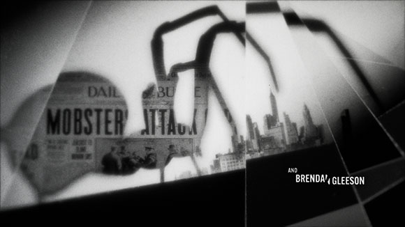 Black and white collage of a large spider silhouette over a city skyline and a newspaper headline reading MOBSTER ATTACK.