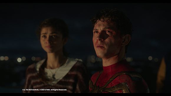 A young man with blood on his face and a young woman looking on with concern against a dark night background.