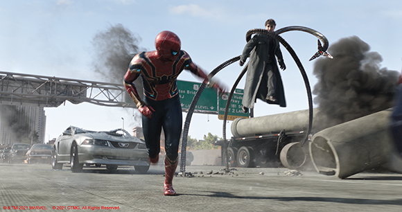 Spider-Man in a red and gold suit runs through a debris-filled street toward a man with large mechanical arms.