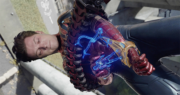 A man in a red and black armored suit holds a glowing blue holographic object.