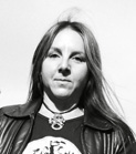 Black and white portrait of a woman with long hair wearing a leather jacket and a necklace.