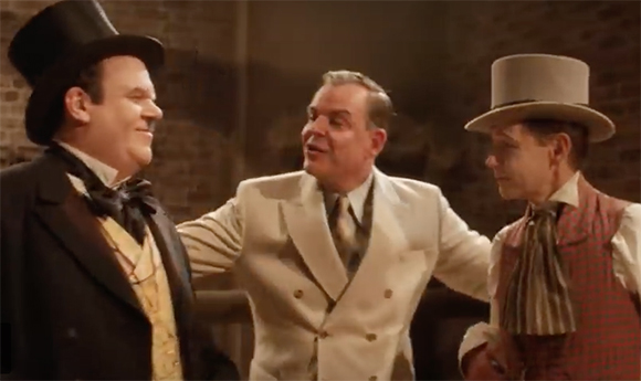 Three men in 19th-century formal attire, including top hats and waistcoats, talking in a dimly lit room.