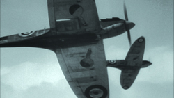 Two vintage fighter aircraft flying through a cloudy sky.